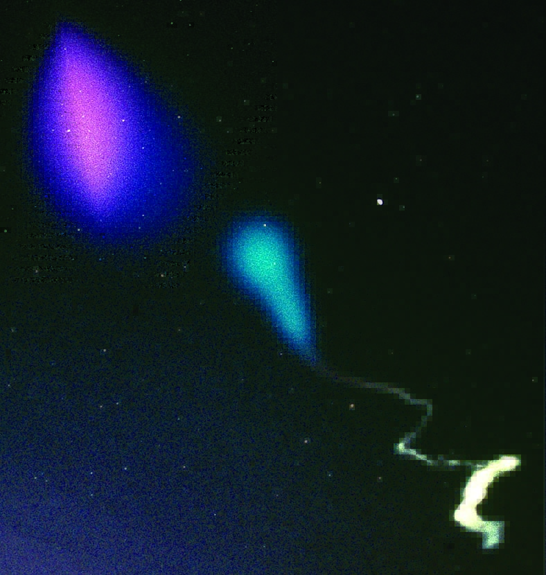 The cloud in the upper left hand part of the image is due to a barium release. The purple-red part is the ionized component which has become elongated along the Earth’s magnetic field lines. The purple-blue cloud that surrounds the red ionized barium is a combination of the neutral barium and strontium. The blue and white trail in the lower portion of the image is from a TMA vapor trail that reveals the neutral wind trails as a function of altitude.